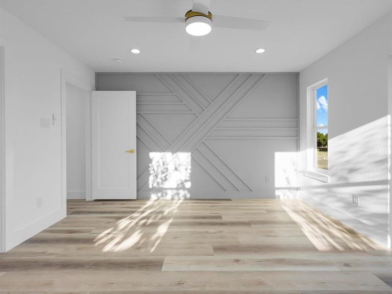 Unfurnished room with ceiling fan and light wood-type flooring