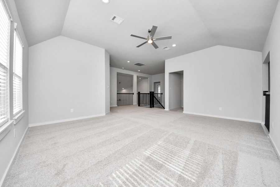 Discover a haven of leisure in this fantastic game room! Whether you're seeking a casual hangout or an adult gaming retreat, this space has it all. Enjoy the luxurious feel of plush carpet underfoot, the expansive ambiance of high ceilings, custom paint that adds a touch of personality, and windows that flood the room with refreshing natural light.