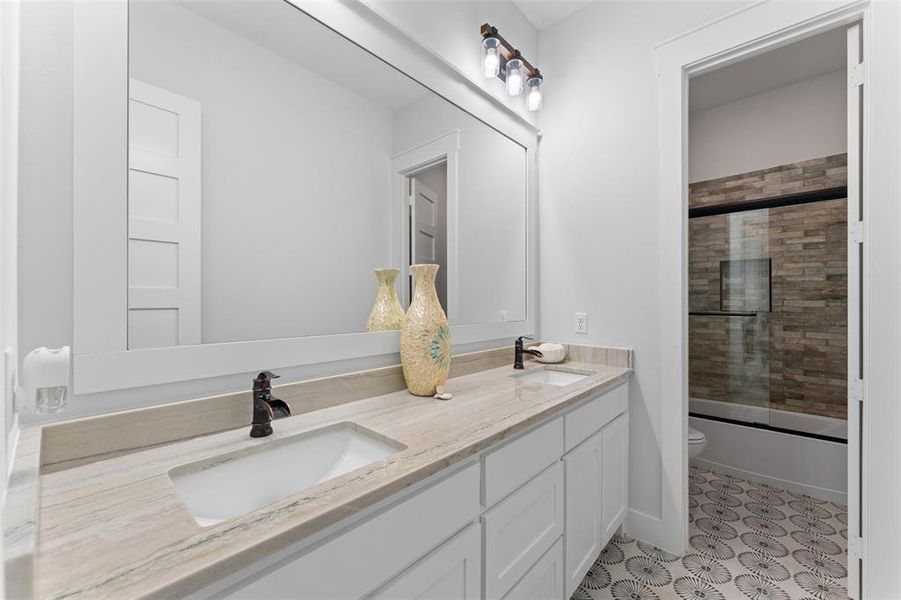 Dual vanity featuring a light-toned countertop, integrated sinks, and dark bronze faucets