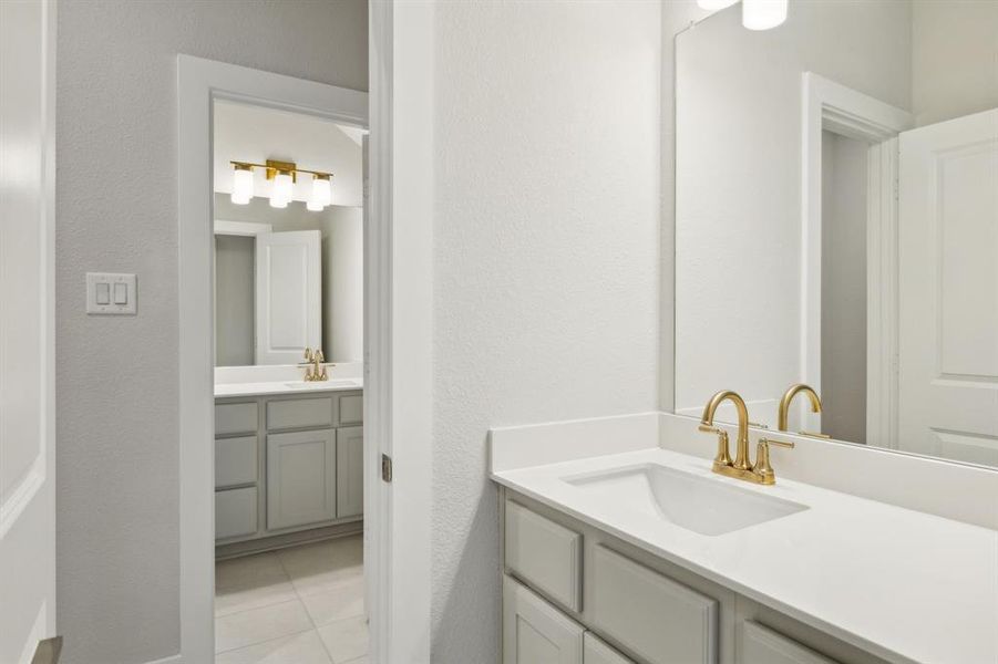 Bathroom with vanity, tile patterned flooring, and a textured wall
