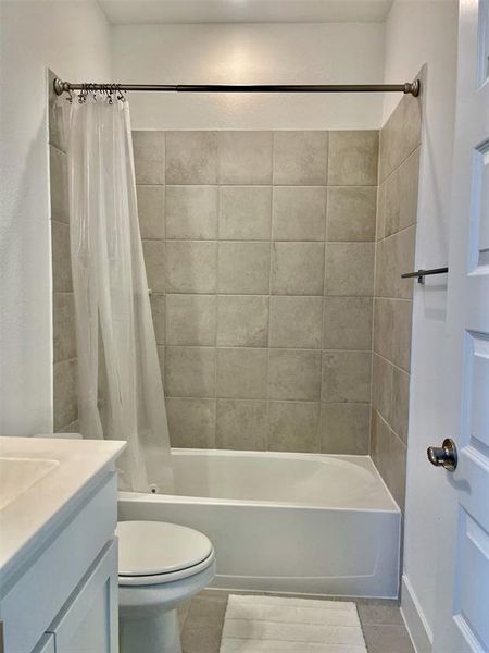 Bathroom with shower / bath combo, light tile patterned floors, and vanity Bathroom with shower / bath combo, light tile patterned floors, and vanity