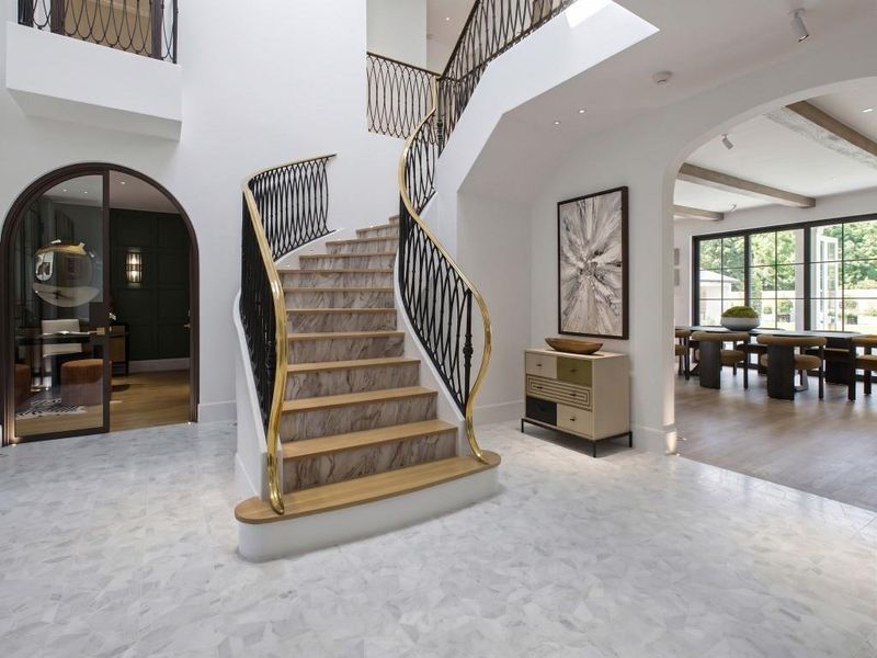 Floating architectural staircase and etched marble entry flooring is the centerpiece of this home.