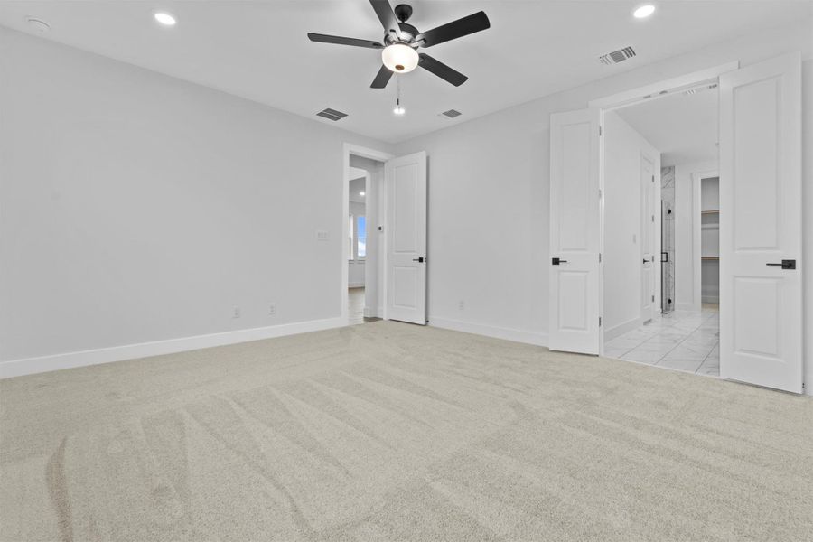 Interior space featuring ceiling fan and light carpet