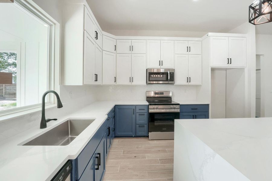 A well-appointed kitchen features sleek countertops, contemporary cabinetry, and modern stainless steel appliances.