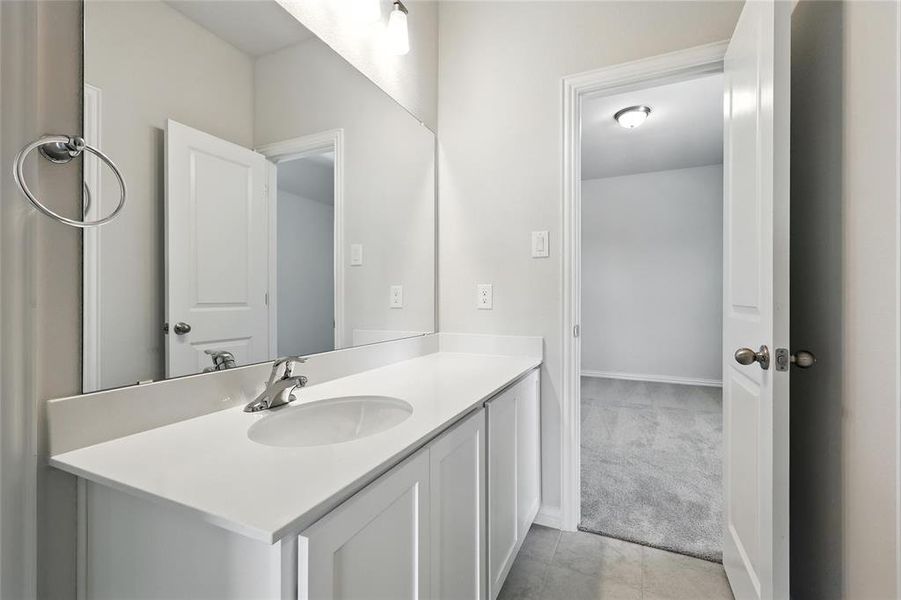 Bathroom featuring vanity, light colored carpet, and light tile patterned floors