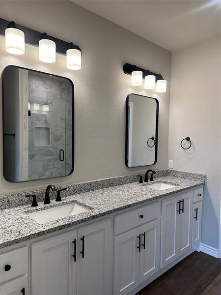 Bathroom featuring vanity, hardwood / wood-style floors, and walk in shower