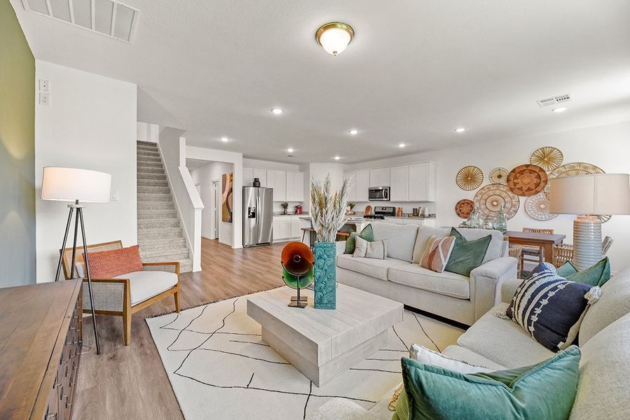 A living room with a staircase. A living room with a staircase.