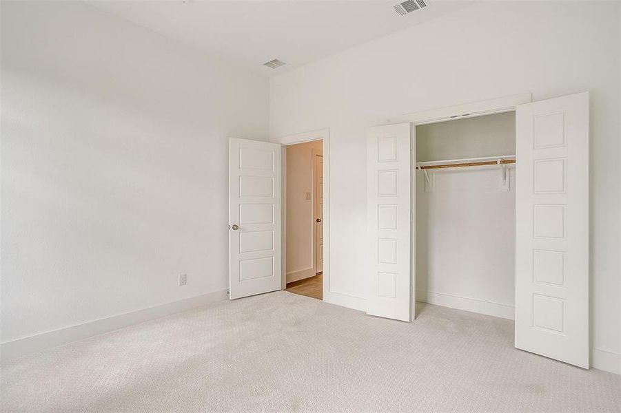 Unfurnished bedroom featuring a closet and light carpet