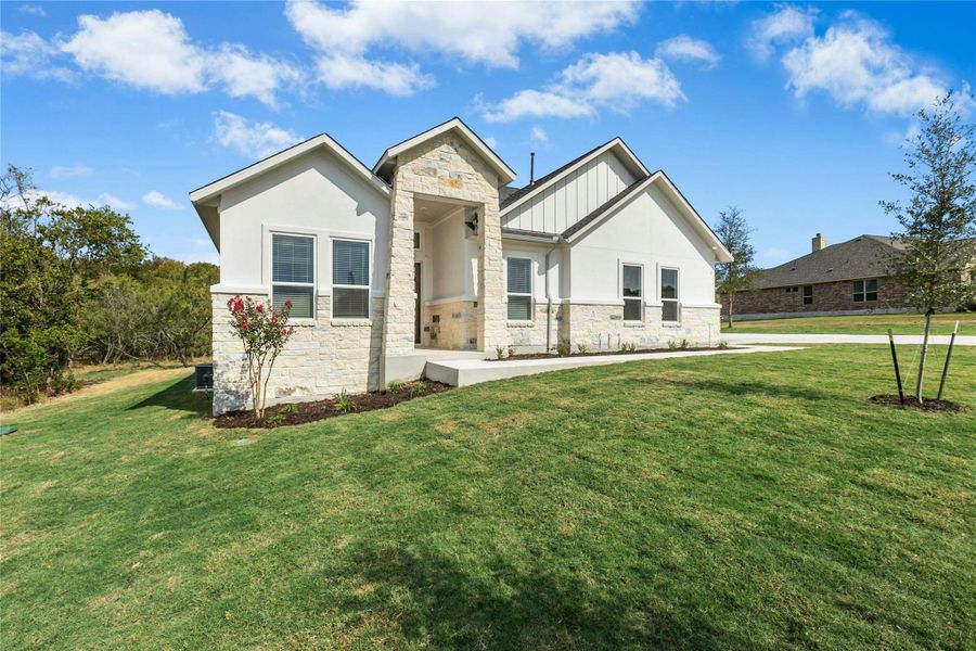 View of front of property featuring stone siding, a front lawn, board and batten siding, and stucco siding View of front of property featuring stone siding, a front lawn, board and batten siding, and stucco siding