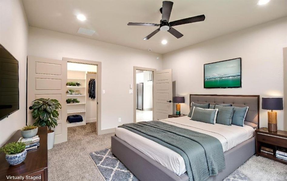 Bedroom with a walk in closet, light colored carpet, a ceiling fan, and recessed lighting