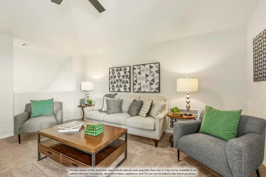 Living room with gray sofa, accent chairs, wood coffee table, and ceiling fan on carpeted floor