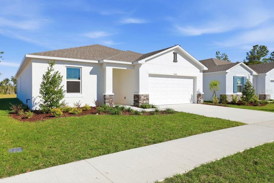 Front exterior of a new home in Palm Wind, Hudson, FL, highlighting curb appeal (Image 21).