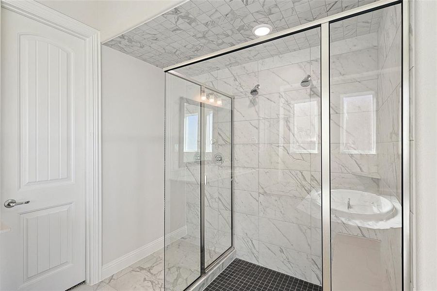 Bathroom featuring a marble finish shower and light marble finish floors