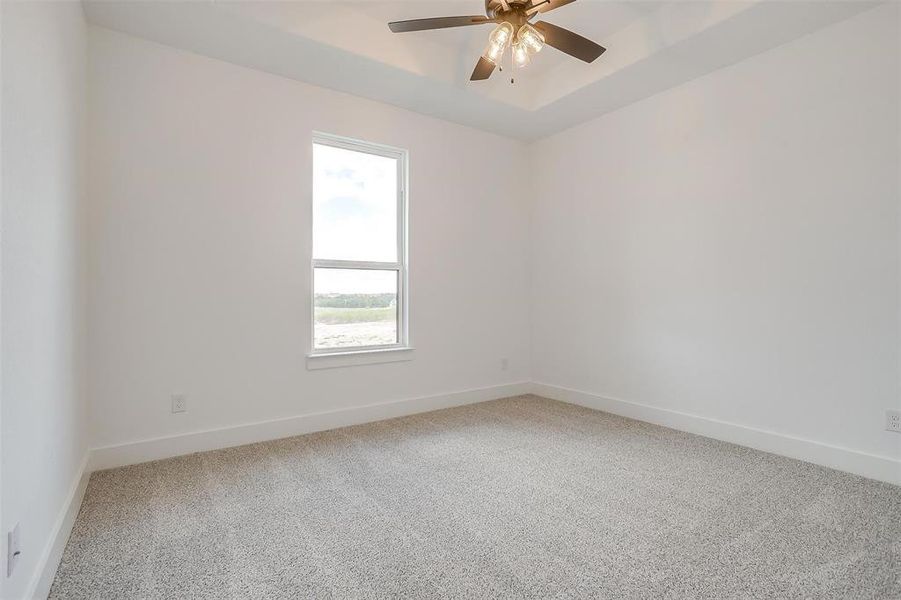 Carpeted empty room with ceiling fan