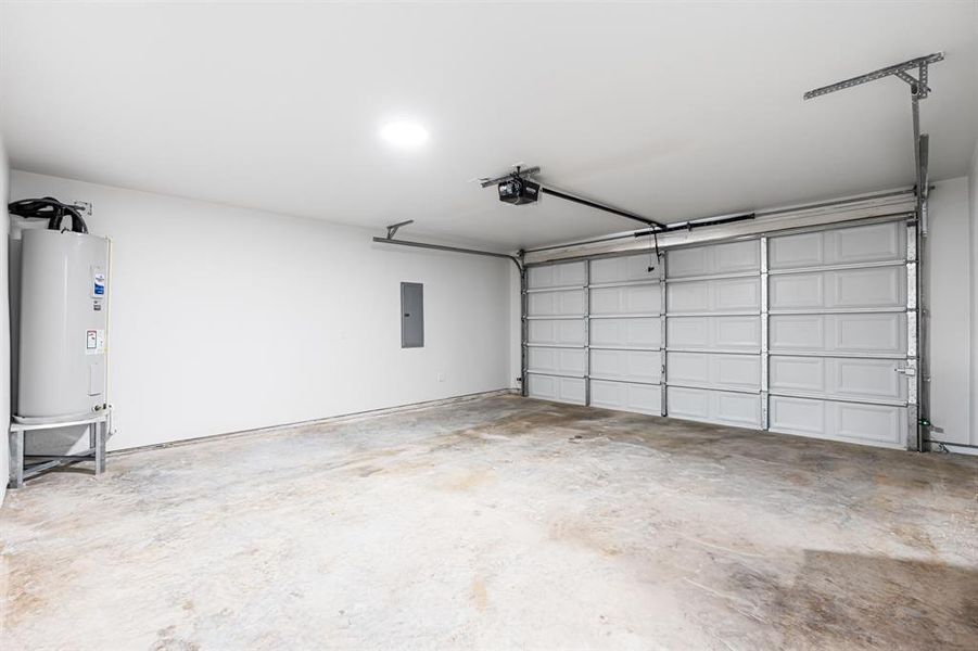 Garage featuring electric water heater and electric panel