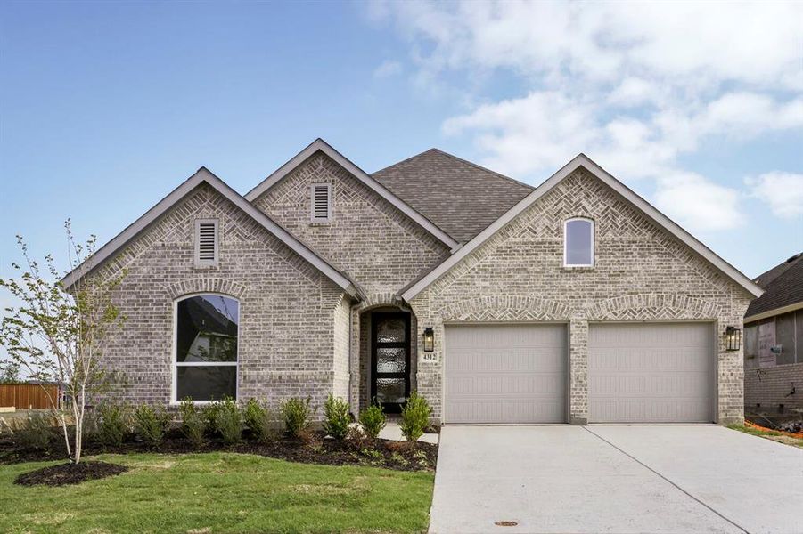 View of front of property featuring brick siding, a garage, concrete driveway, and a front yard