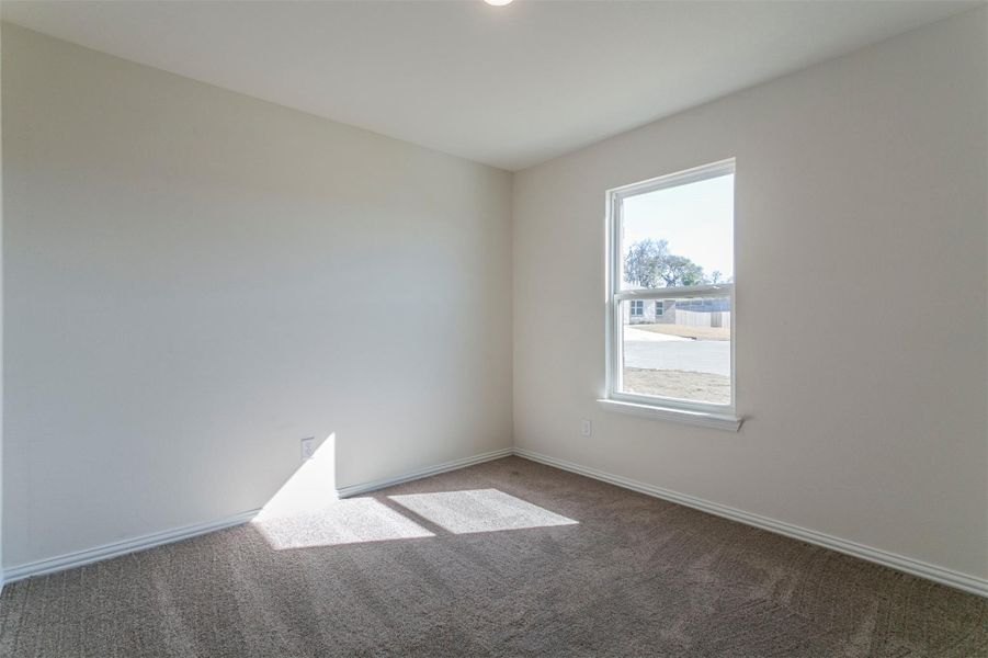 Carpeted spare room featuring baseboards Carpeted spare room featuring baseboards