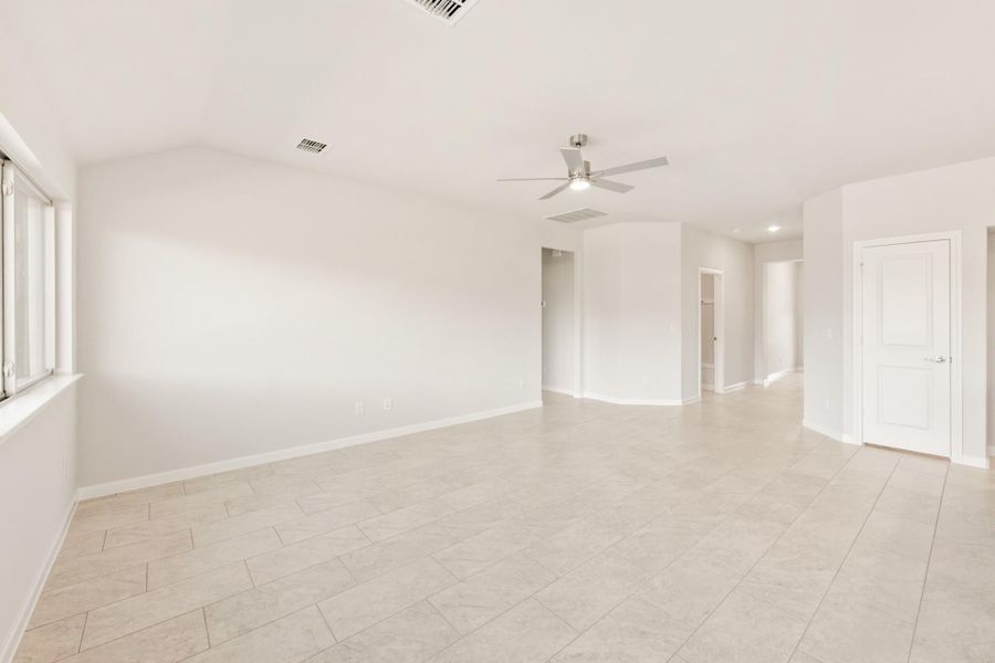 Empty living room with light tile floors, white walls, and ceiling fan Empty living room with light tile floors, white walls, and ceiling fan
