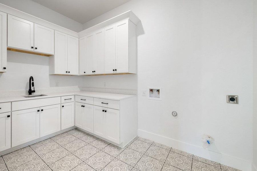 Laundry area featuring hookup for a gas dryer, cabinet space, washer hookup, and light tile patterned flooring