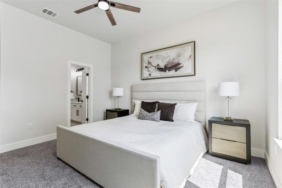 Bedroom featuring ceiling fan, carpet, and ensuite bathroom