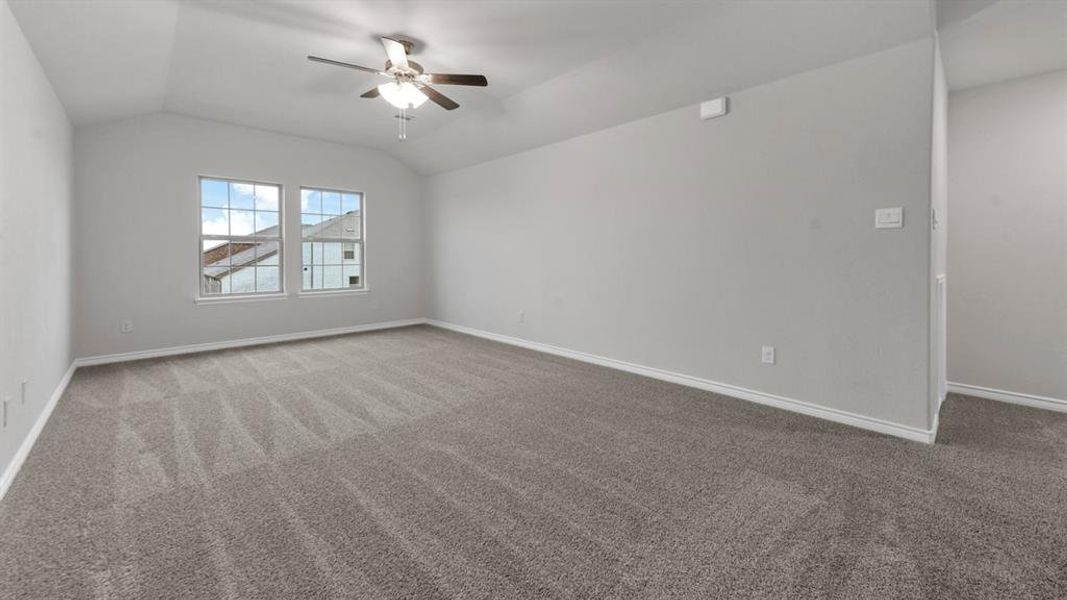 Unfurnished room featuring ceiling fan, light colored carpet, and vaulted ceiling Unfurnished room featuring ceiling fan, light colored carpet, and vaulted ceiling