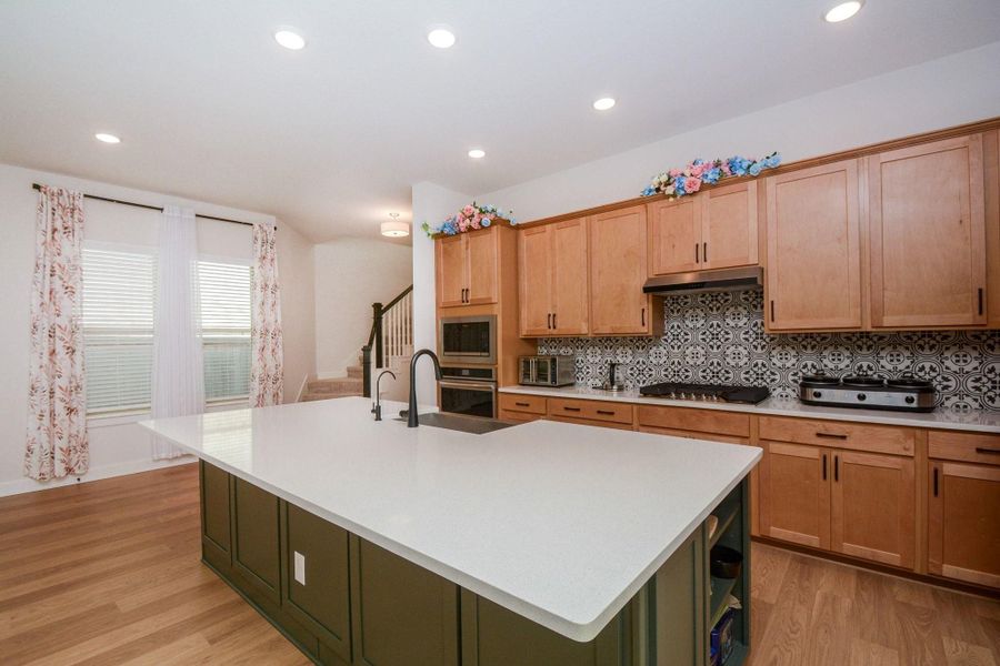 This view highlights the natural flow of the home, where the kitchen serves as the central gathering place with easy access to the dining area, living spaces, and second floor. It's a layout designed to keep everyday living comfortable, connected, and convenient.