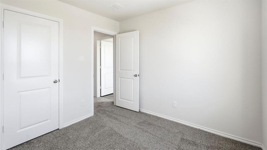 Unfurnished bedroom featuring dark carpet and baseboards