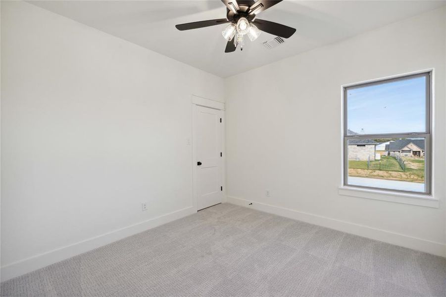 Carpeted spare room featuring ceiling fan