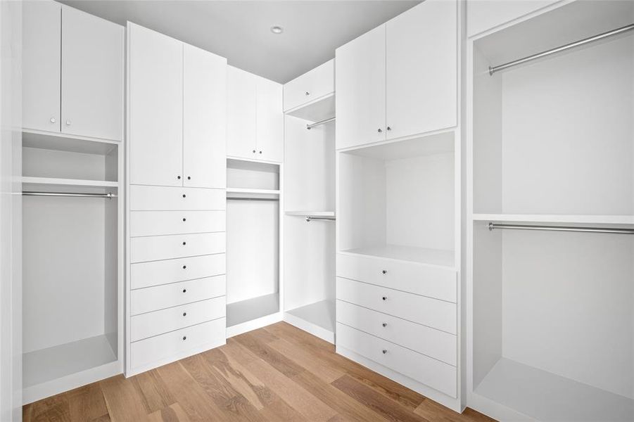 The second primary closet offers extensive built-in storage, including custom shelving and hanging racks, all accented by polished nickel hardware. Both of the dual primary closets ensure a clutter-free and elegant space to keep everything neatly organized.