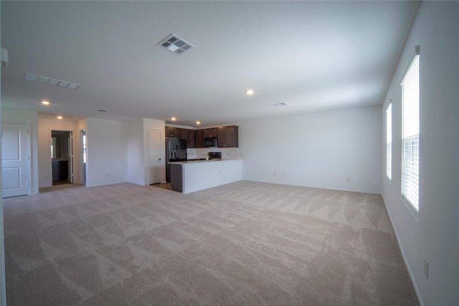 Unfurnished living room with light carpet and recessed lighting