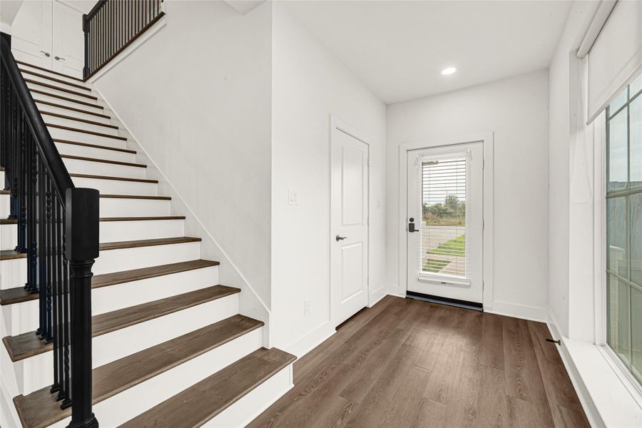 Upon entering, you are greeted with an abundance of natural light leading to the wrought-iron spindle staircase.The door leads to a half-bath perfect for guests.