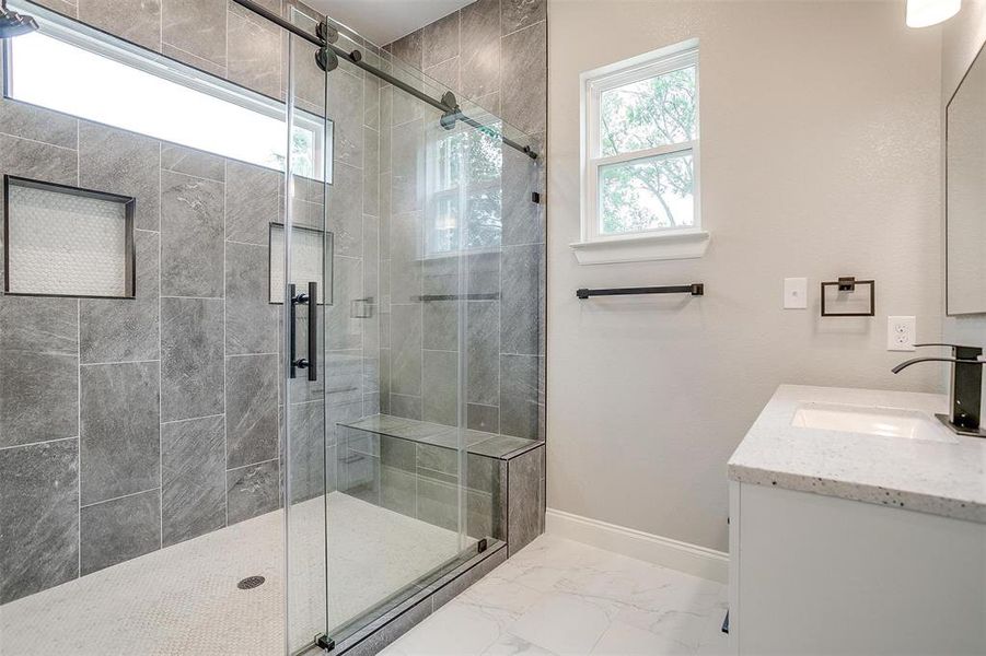 Full bathroom with baseboards, marble finish floor, a stall shower, and vanity Full bathroom with baseboards, marble finish floor, a stall shower, and vanity