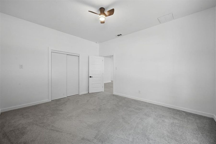 Unfurnished bedroom featuring carpet floors, a closet, and a ceiling fan Unfurnished bedroom featuring carpet floors, a closet, and a ceiling fan