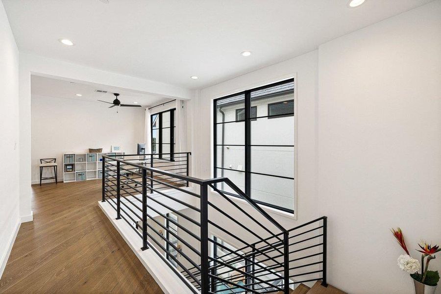 Modern black metal stair railing system with wood-finish flooring