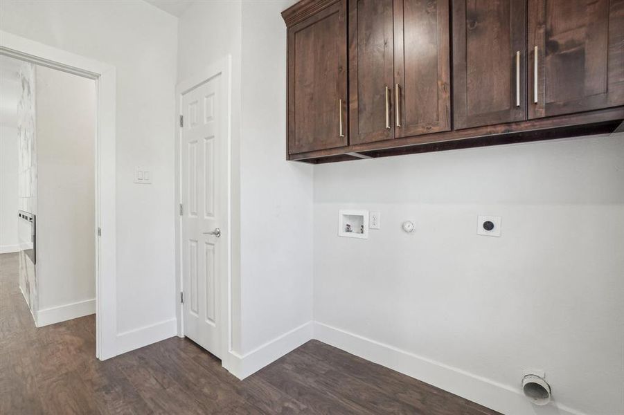 Laundry room featuring cabinets, hookup for a washing machine, dark wood-type flooring, electric dryer hookup, and hookup for a gas dryer