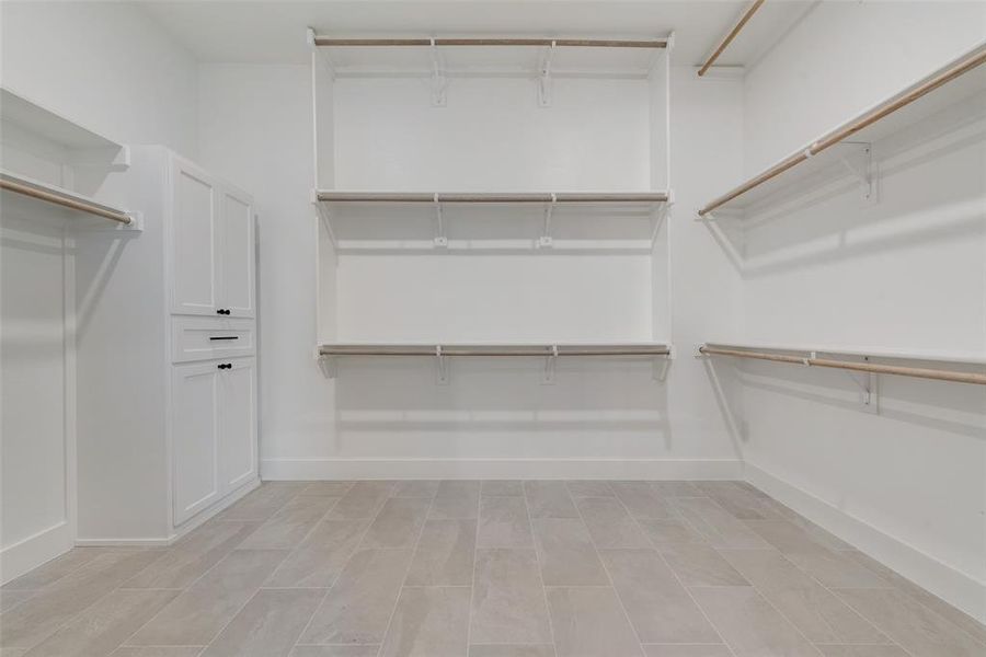 Walk in closet featuring light tile floors