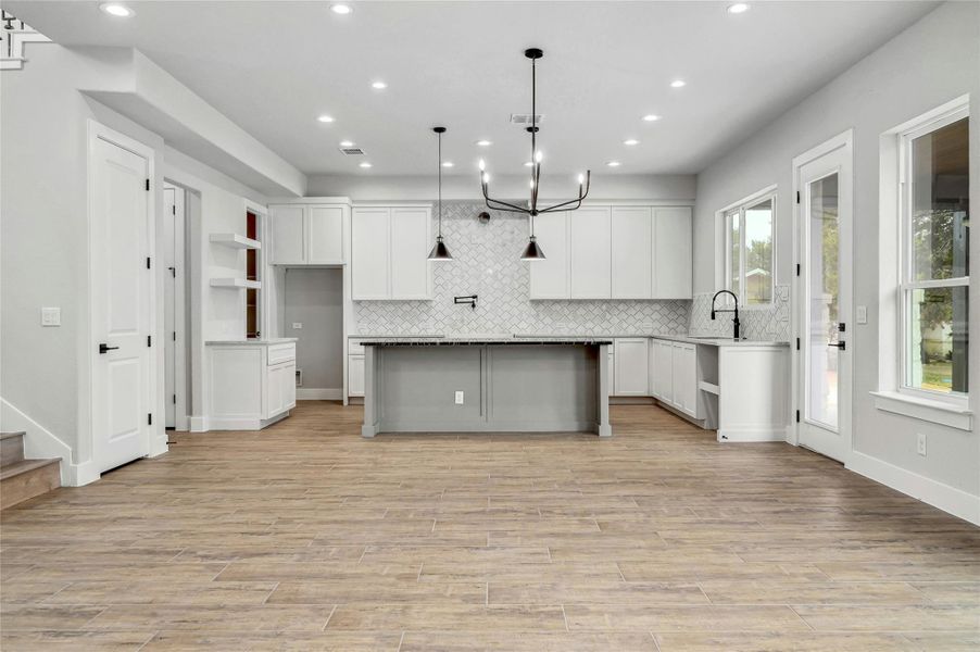 Kitchen featuring light wood-style flooring, decorative backsplash, and recessed lighting