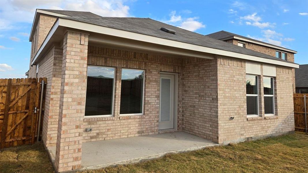 Back of property featuring a patio area, brick siding, a gate, and roof with shingles Back of property featuring a patio area, brick siding, a gate, and roof with shingles