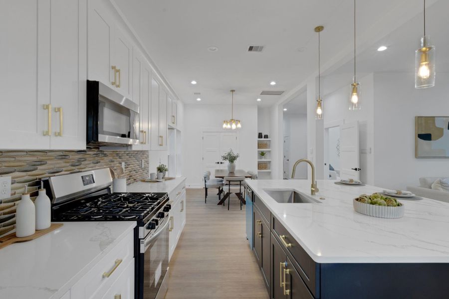 Gourmet kitchen featuring quartz countertops, stylish backsplash, and a large island with pendant lighting—perfect for entertaining. Gourmet kitchen featuring quartz countertops, stylish backsplash, and a large island with pendant lighting—perfect for entertaining.