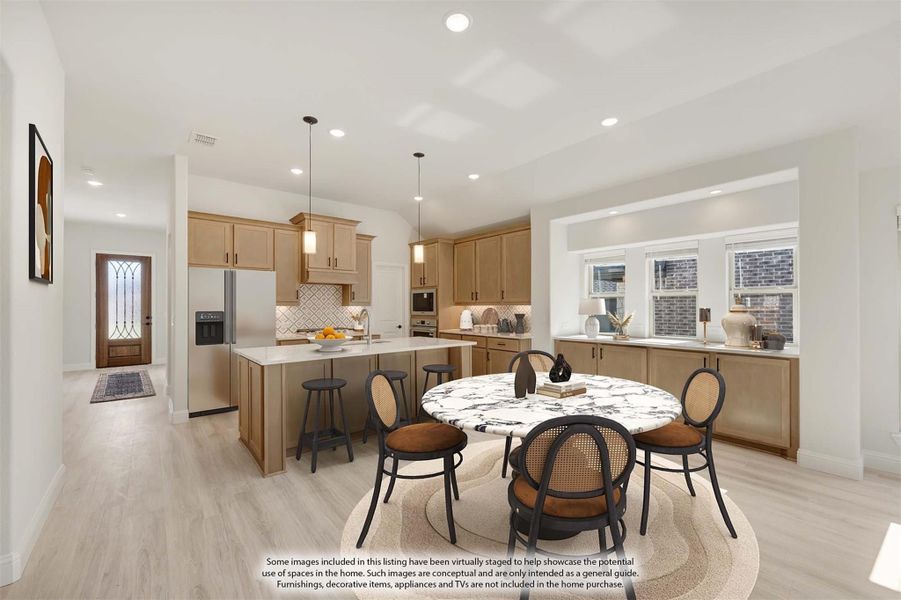 Open kitchen and dining area with light wood cabinets, center island, marble dining table, and light hardwood floors