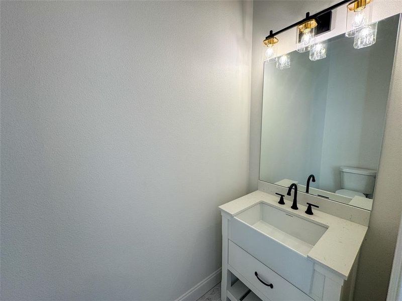 Half bathroom featuring vanity and toilet Half bathroom featuring vanity and toilet