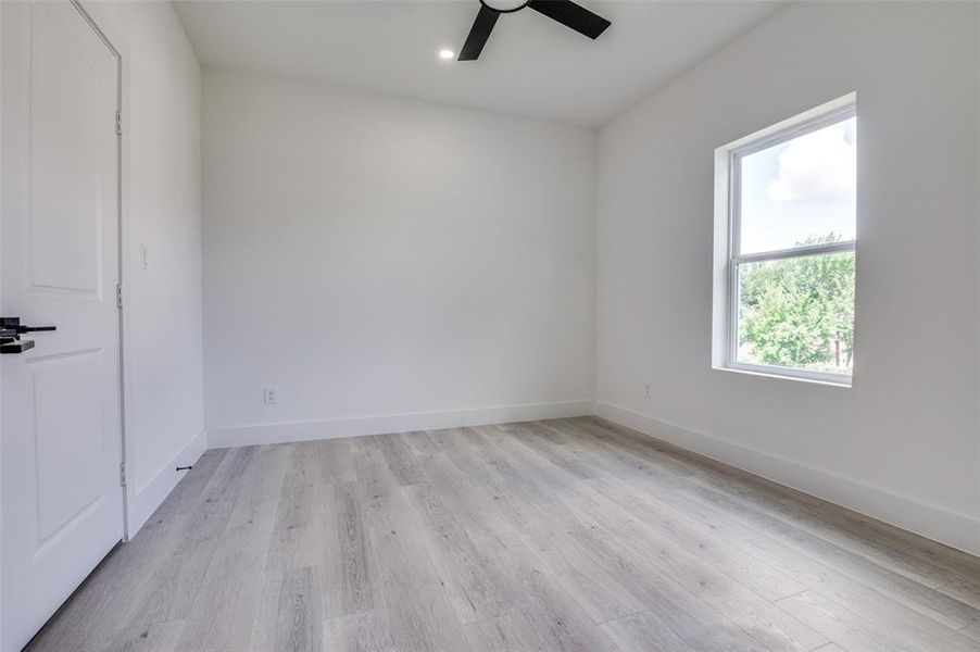 Empty room featuring a ceiling fan, light wood-type flooring, and recessed lighting Empty room featuring a ceiling fan, light wood-type flooring, and recessed lighting