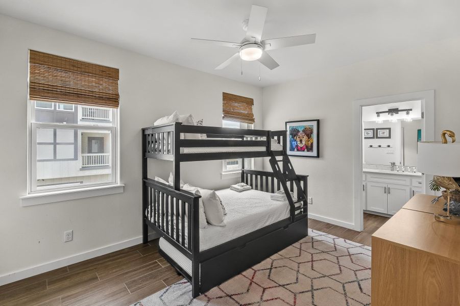Bedroom with wood tiled floors, a ceiling fan, and connected bathroom Bedroom with wood tiled floors, a ceiling fan, and connected bathroom