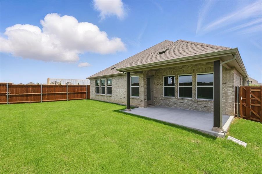 Rear view of property featuring brick siding, a fenced backyard, a patio, and a gate Rear view of property featuring brick siding, a fenced backyard, a patio, and a gate