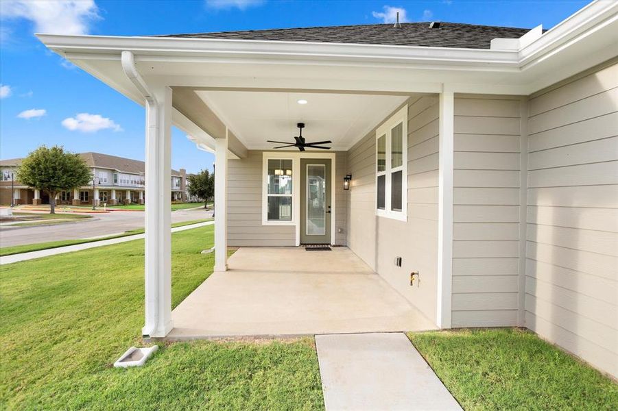 Doorway to property with a yard and ceiling fan