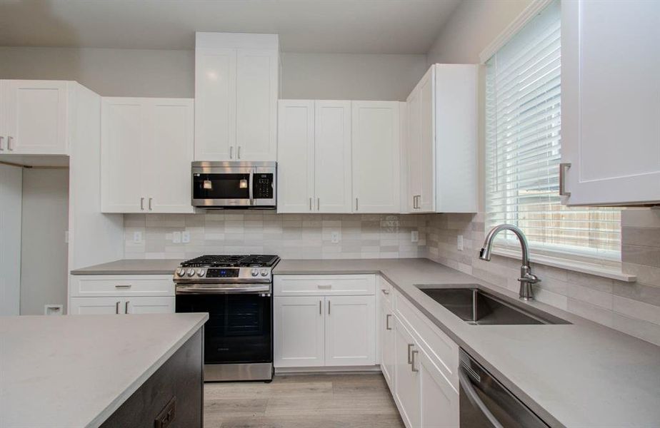 Stainless steel appliances and gorgeous cabinetry. (Transitional finish shown).