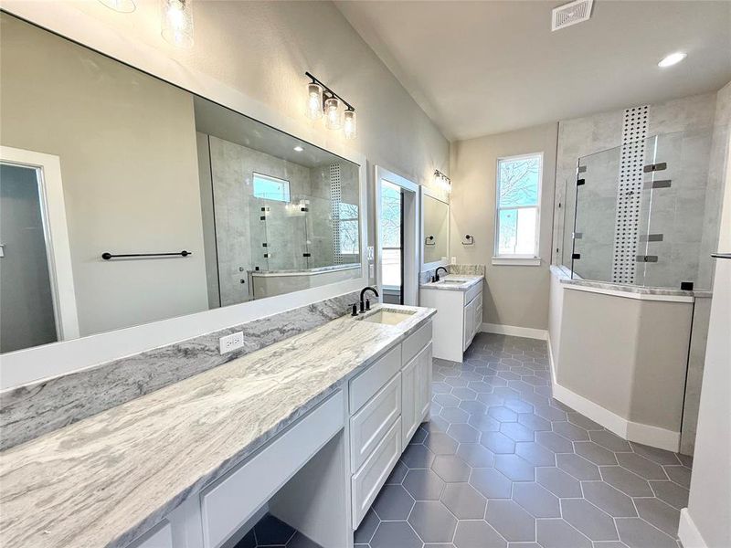 Bathroom with a walk in shower, two vanities, dark tile patterned floors, and recessed lighting Bathroom with a walk in shower, two vanities, dark tile patterned floors, and recessed lighting
