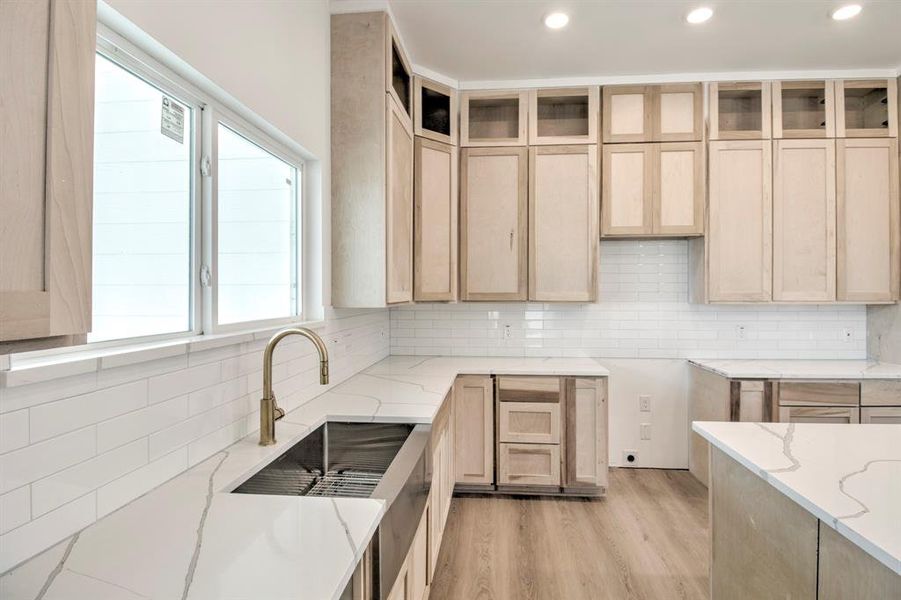 Kitchen featuring light brown cabinets, backsplash, light wood-style flooring, light stone countertops, and recessed lighting Kitchen featuring light brown cabinets, backsplash, light wood-style flooring, light stone countertops, and recessed lighting
