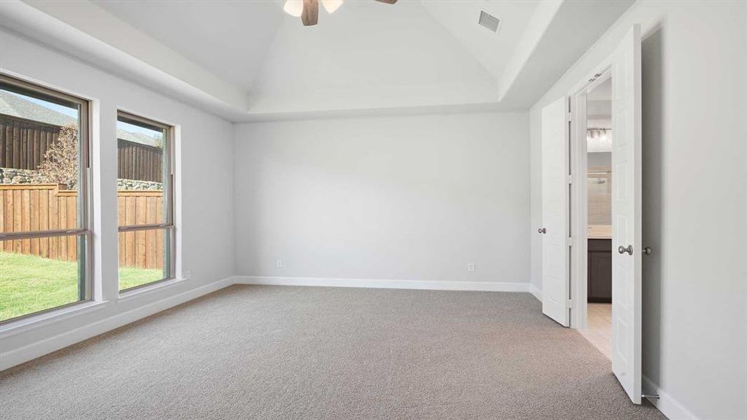 Unfurnished room featuring ceiling fan, carpet, and vaulted ceiling