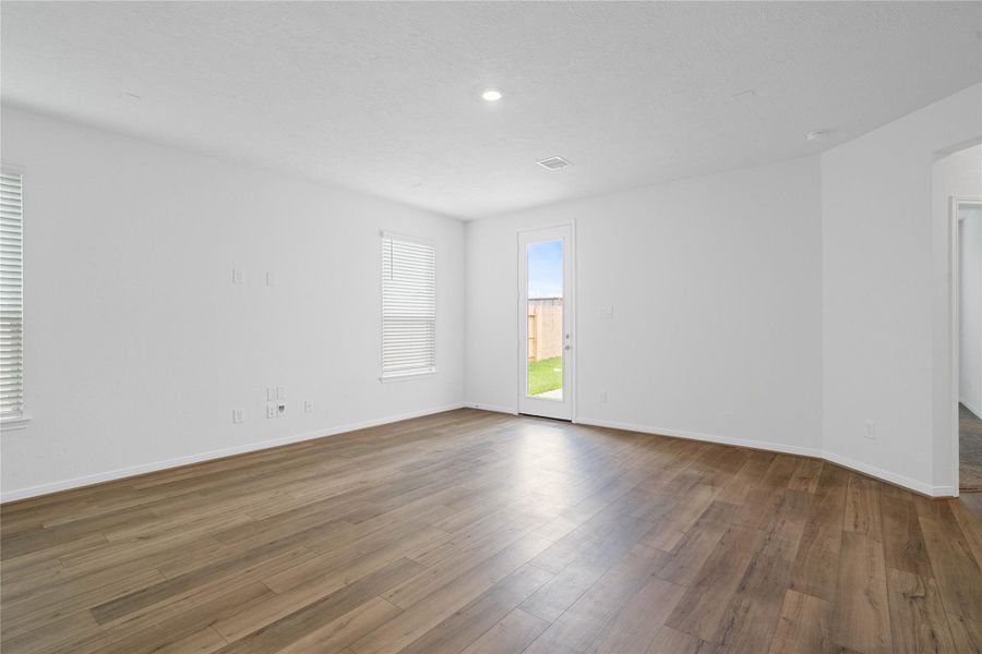 This bright and airy Great Room offers a spacious layout ideal for both relaxing evenings and lively gatherings. Designed for comfort and connection, it features vinyl plank flooring, large windows with blinds, high ceilings, recessed lighting, and access to backyard through the back door—easy transition from indoor living to outdoor entertaining. This bright and airy Great Room offers a spacious layout ideal for both relaxing evenings and lively gatherings. Designed for comfort and connection, it features vinyl plank flooring, large windows with blinds, high ceilings, recessed lighting, and access to backyard through the back door—easy transition from indoor living to outdoor entertaining.